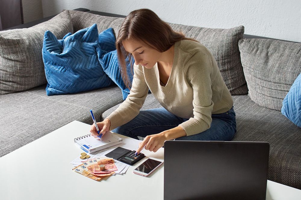 Foto: Frau mit Taschenrechner und Bargeld